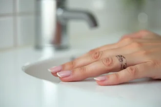 Gros plan d'un ongle de doigt présentant une décoloration et un épaississement caractéristiques d'une mycose ou d'une infiltration unguéale